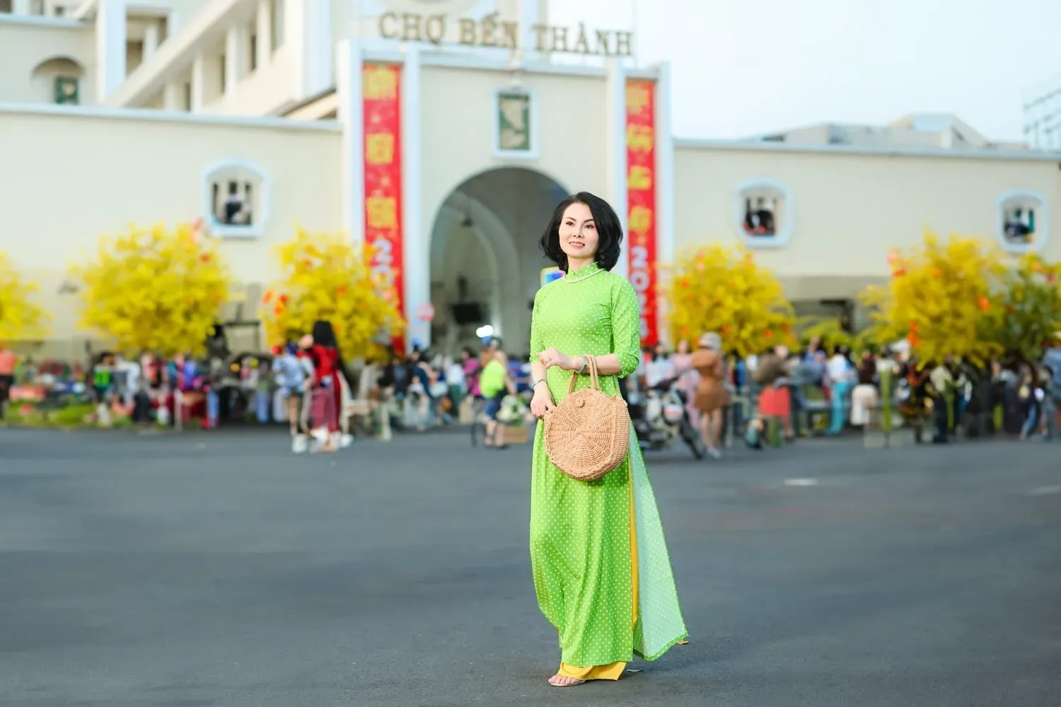Chụp ảnh áo dài trước cổng chợ Bến Thành được nhiều phái đẹp yêu thích vào mùng 1 Tết