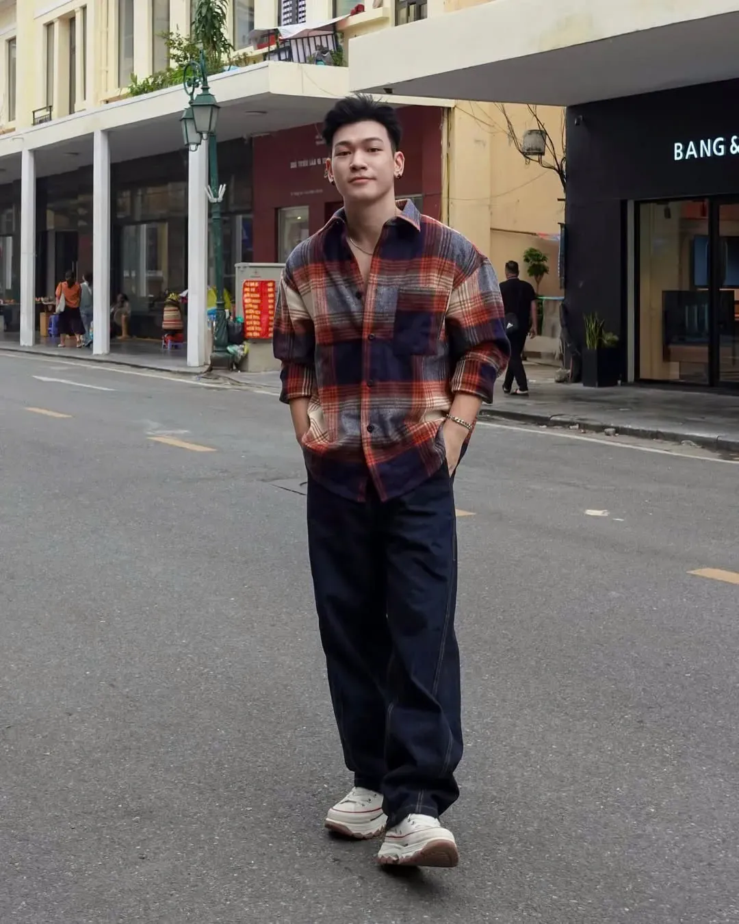 Áo sơ mi kẻ ô lớn kết hợp với quần jeans tối màu tạo nên sự thoải mái, đồng thời vẫn giữ được nét lịch sự và phong cách