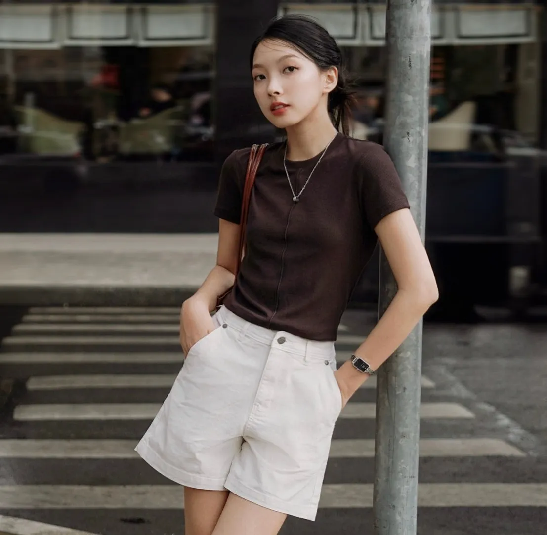 Áo thun nâu đất dáng ôm kết hợp cùng quần short trắng phù hợp với outfit đi dạo phố (Nguồn: Routine)