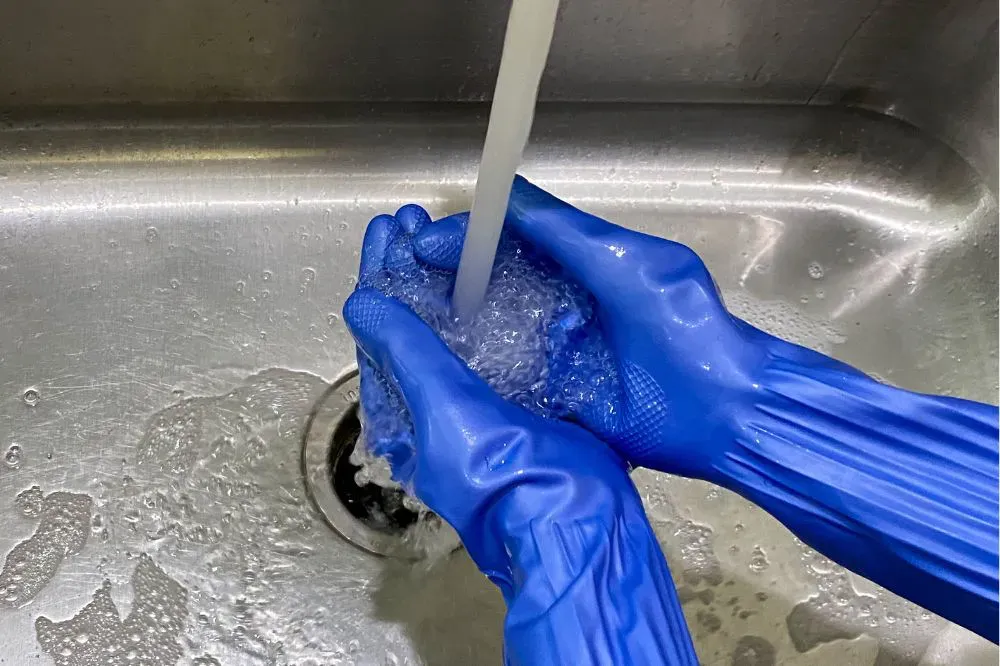 Người dùng đeo găng tay khi thao tác với dung dịch thuốc tím để hạn chế tiếp xúc trực tiếp với hóa chất