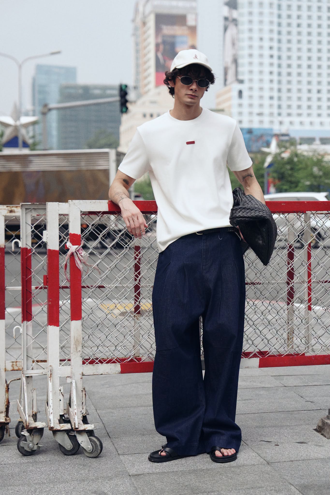Quần jeans ống rộng đi cùng áo thun trắng, mũ lưỡi trai và sandal tạo nét năng động cho chuyến vi vu Đà Nẵng