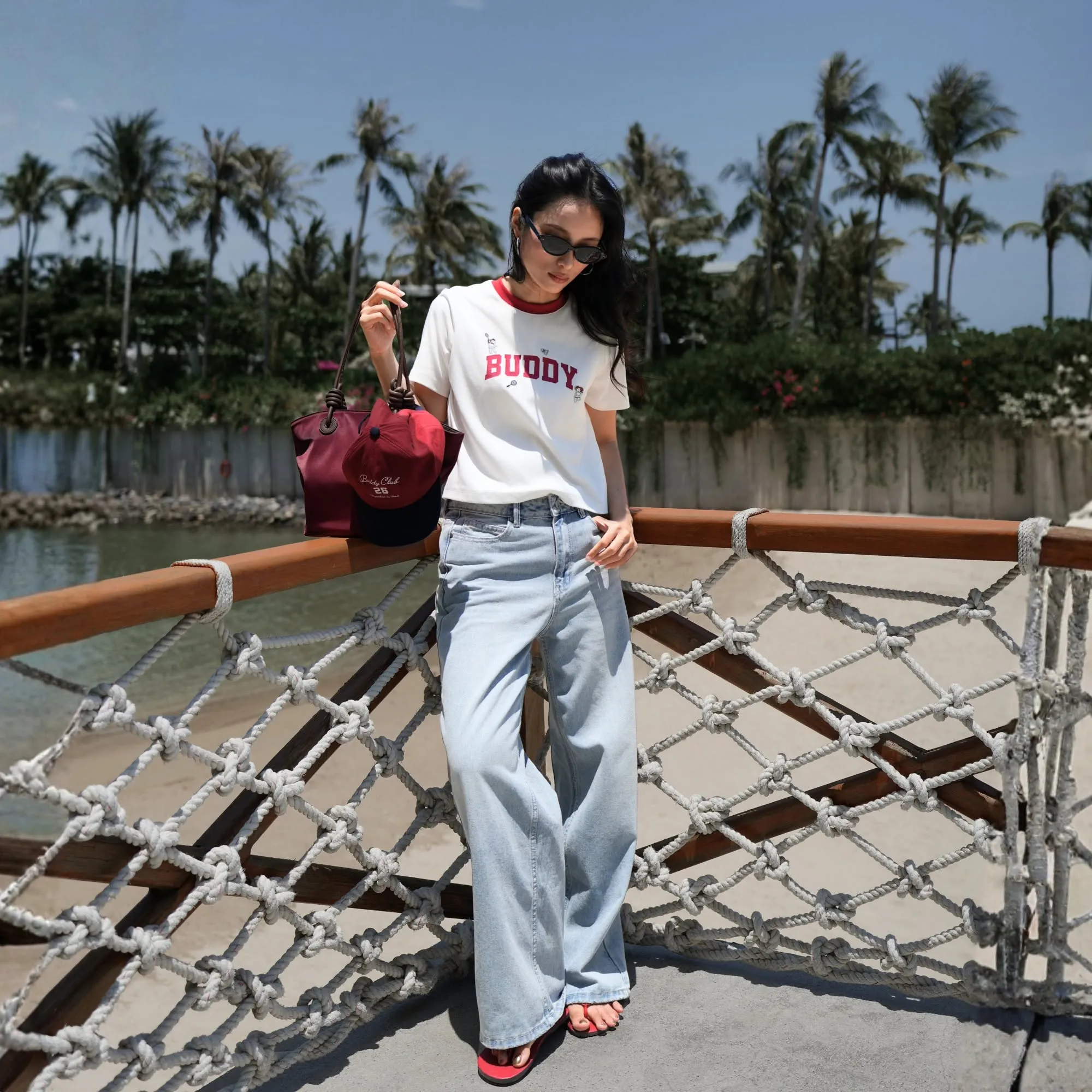 Quần jeans ống rộng phối áo thun graphic và kính râm đem đến nét năng động, trẻ trung
