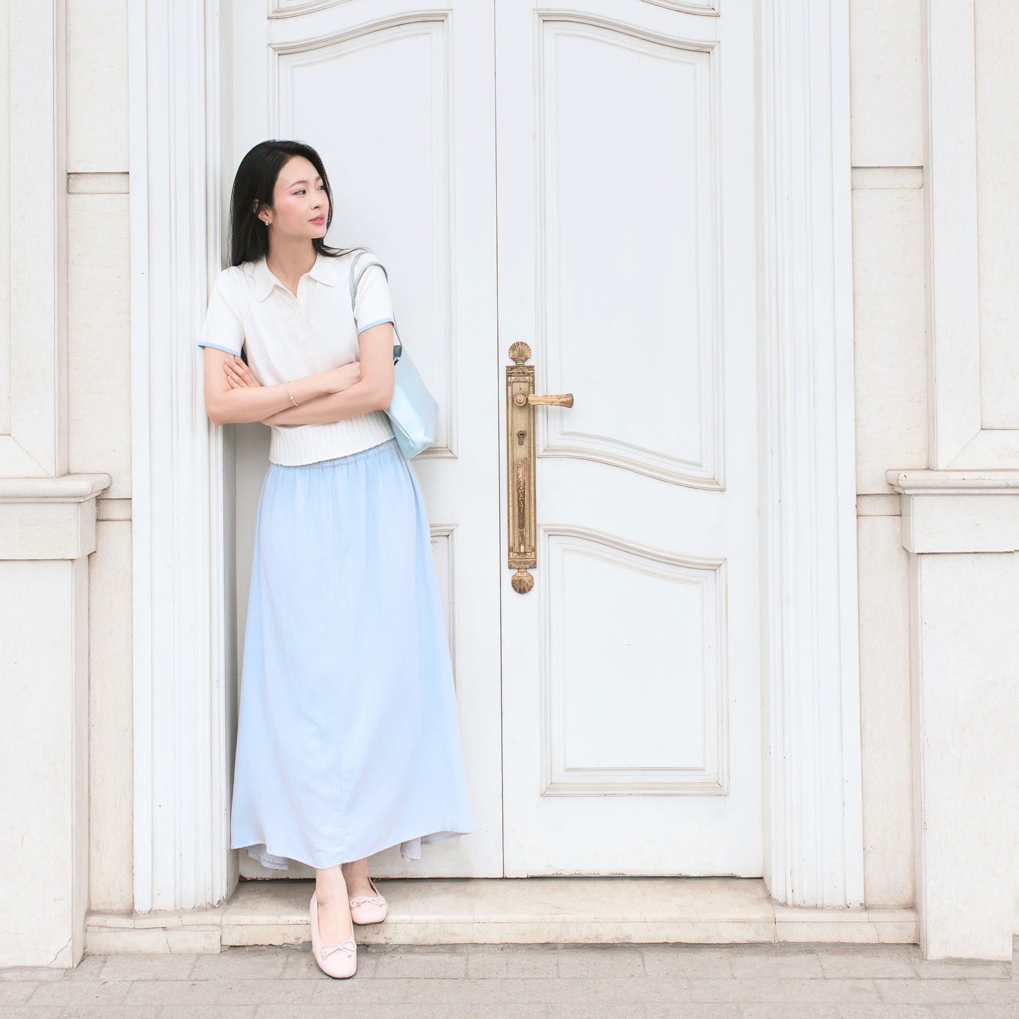 Áo polo trắng phối chân váy dài xanh pastel và giày búp bê nhẹ nhàng, thích hợp cho những bức ảnh giữa đồi cát Mũi Né