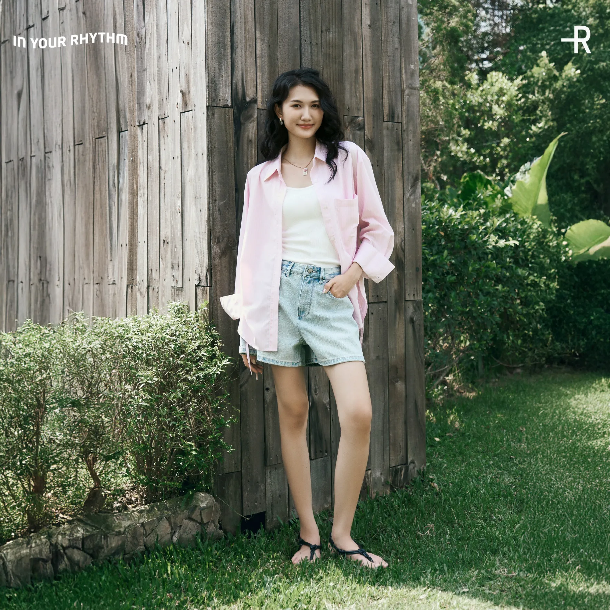 Sơ mi hồng pastel kết hợp quần short jeans nổi bật dưới nắng biển