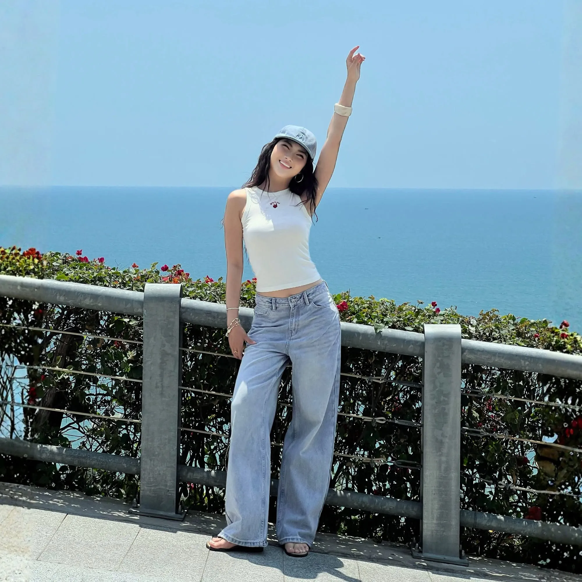 Áo tank top phối quần jeans sáng màu và mũ lưỡi trai, thích hợp cho những buổi check-in dưới nắng biển