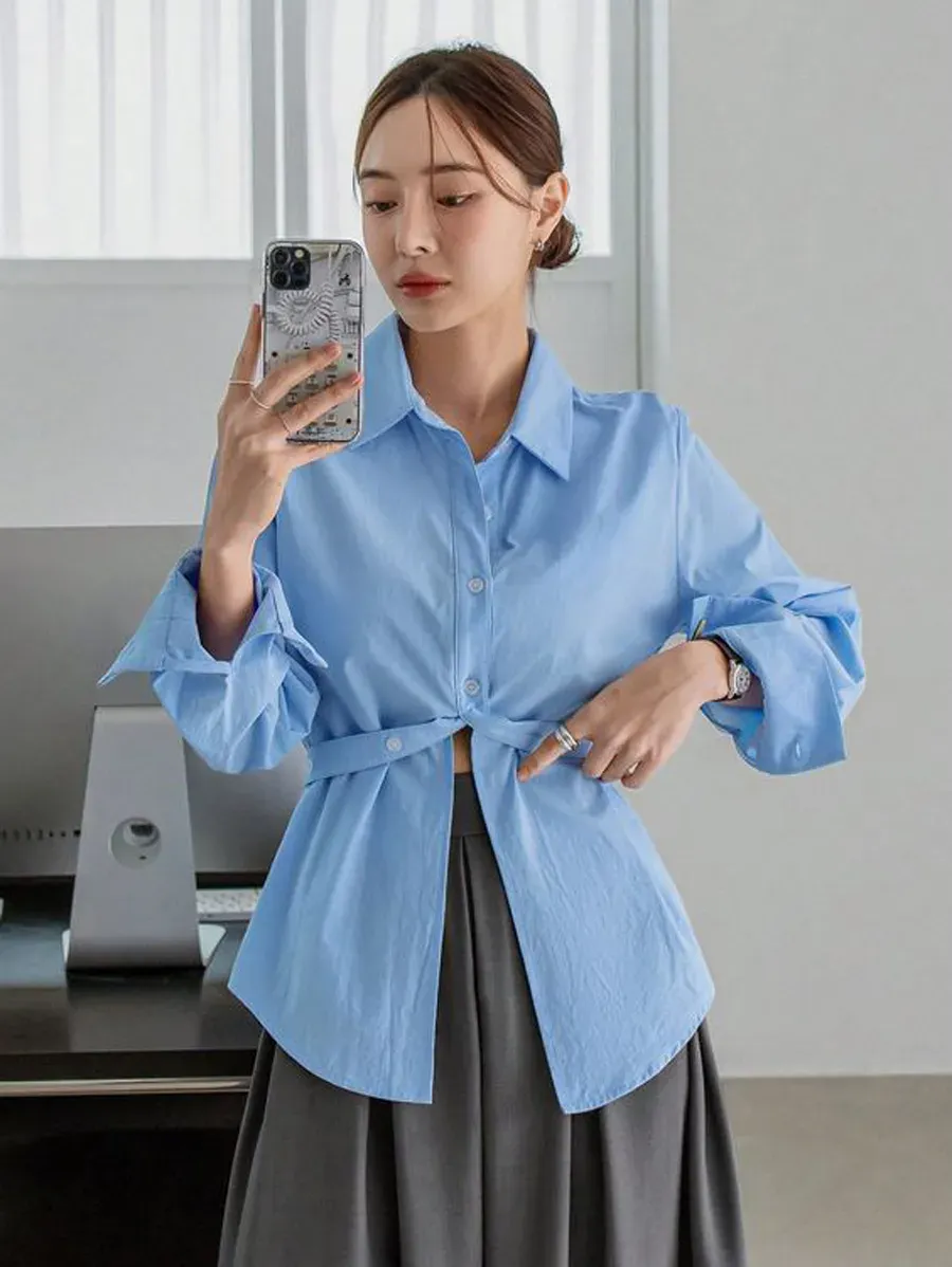 Outfit công sở thanh lịch với áo sơ mi cách điệu màu xanh da trời và chân váy xám (Nguồn: Internet)