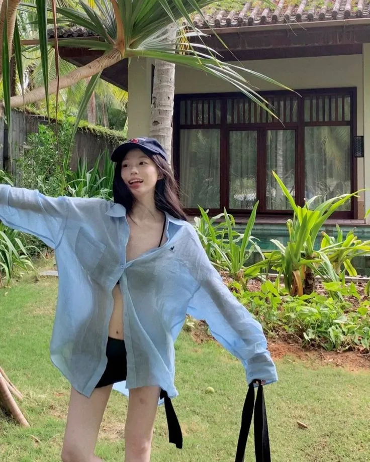 Áo sơ mi xanh mỏng tạo điểm nhấn thu hút ánh nhìn khi phối cùng bộ bikini đen
