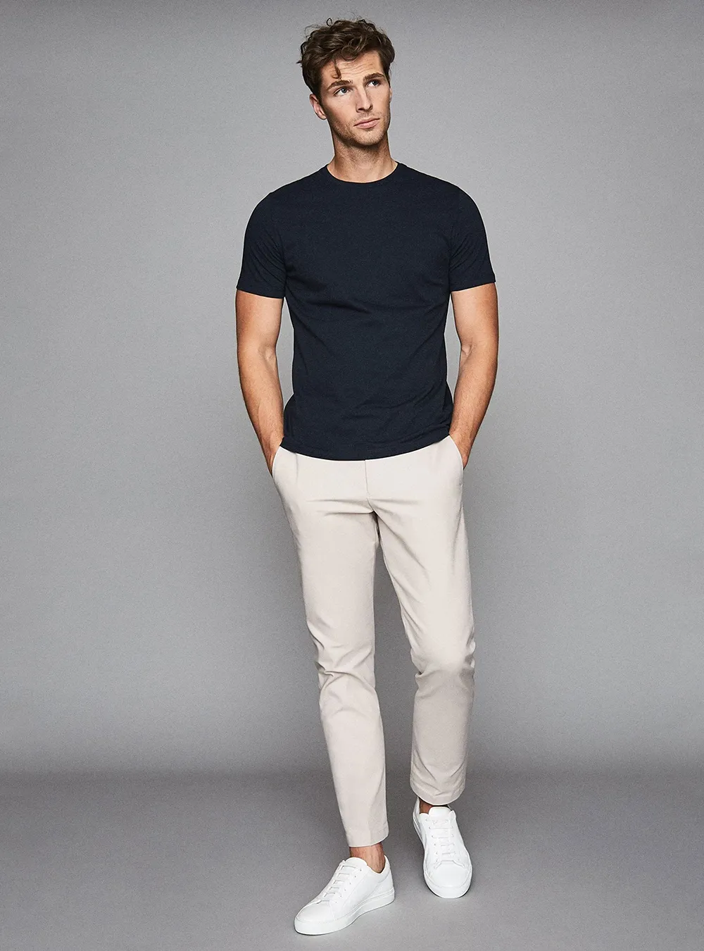 Trẻ trung với trang phục polo nam màu xanh navy kết hợp quần chinos trắng (Nguồn: Internet)